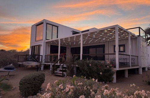 El Sargento House | 3 bedroom, 3 bath premium repurposed shipping container home. Game room w/darts, shuffleboard, video game cabinet, Infinity game table, new 8 person hot tub, multiple decks w/firepits, fast Wifi (250 mb+)w/Starlink backup. Free use of two SUPs.