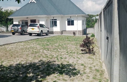 Mbezi House | A Large Bedroomm With Next to the Seating Room
