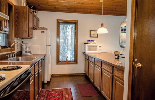 Bessemer House | A Spacious Vacation Home in a Wooded Setting With A Brick Fireplace