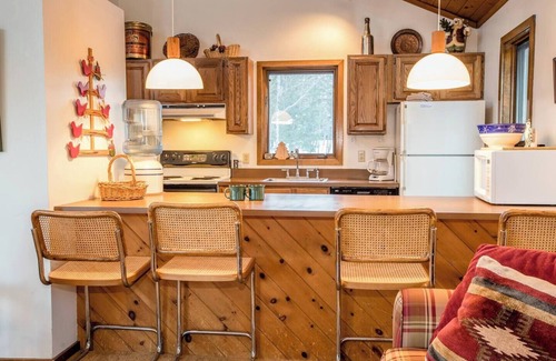 Bessemer House | A Spacious Vacation Home in a Wooded Setting With A Brick Fireplace