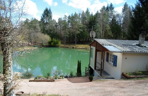 Augignac Ski Chalet | Chalet overlooking a pond in a green setting.