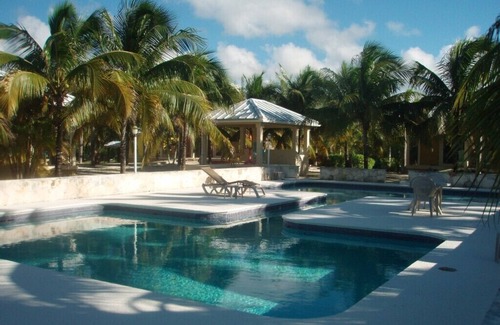 Sandy Point Cottage | Cottage in an Oasis of Palm Tree's with a Pool - 5mn from Beach!