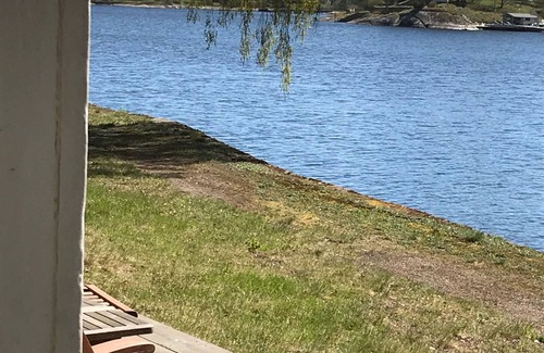 Boo House | Cottage with sunny wooden deck by water. Rowing boat included.