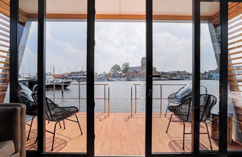 Grou Boat Rental | Houseboat Skoft with beautiful view over the water and on village Grou.