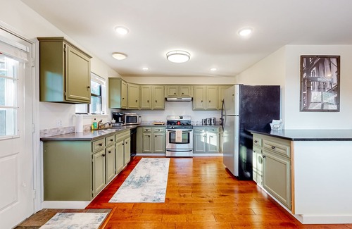 Powell House | Lakefront retreat with screened sunroom, wood stove, multiple decks, & AC