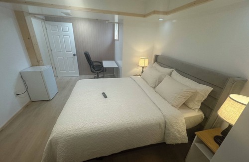Ottawa Division House | Large bedroom with private bathroom and workspace.