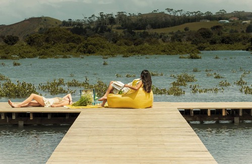 Pouto Cottage | Luxury eco-design waterfront fishing Batch with guests' vegetable garden.