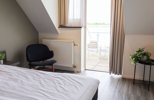 Municipality of West Maas en Waal House | Luxury room with a balcony overlooking De Gouden Ham, offering modern amenities and a serene, picturesque setting.