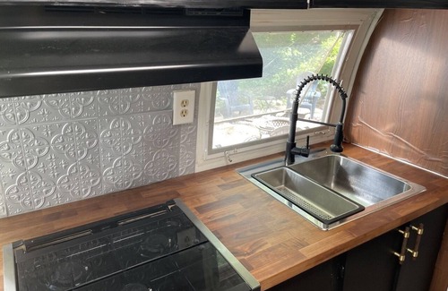 Changewater RV Rental | Modern Styled Vintage Airstream Nestled by a Stream on a Picturesque Tree Farm