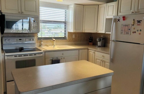 Marco Island Condo | Modern top floor with a beautiful view of the bay, pool, waterfront restaurant