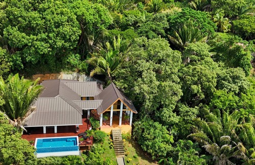 Gibson Bight House | Relax at this hillside retreat that overlooks the lush forest and the Caribbean.