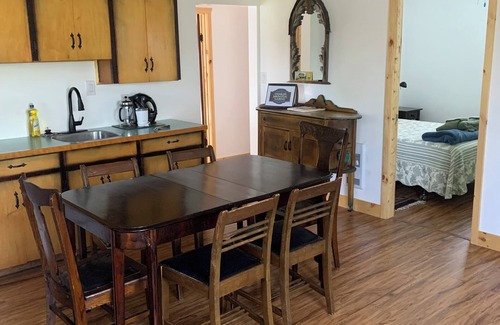 Manitoba Cottage | Rustic cabin near RMNP with screened-in deck, meadow view, and wood stove