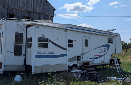 Asphodel-Norwood House | Serenity Lane Farm Stay: a trailer next to a barn full of farm animals
