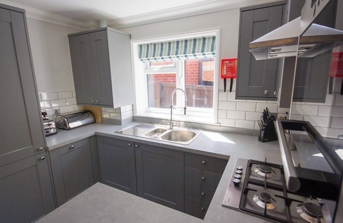 Rookley Cottage | Single-storey stylish open-plan living with French doors onto a deck and hedged lawn.