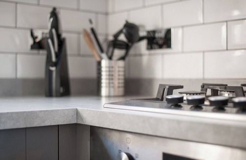 Rookley Cottage | Single-storey stylish open-plan living with French doors onto a deck and hedged lawn.