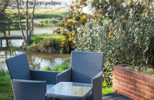Rookley Cottage | Single-storey stylish open-plan living with French doors onto a deck and hedged lawn.