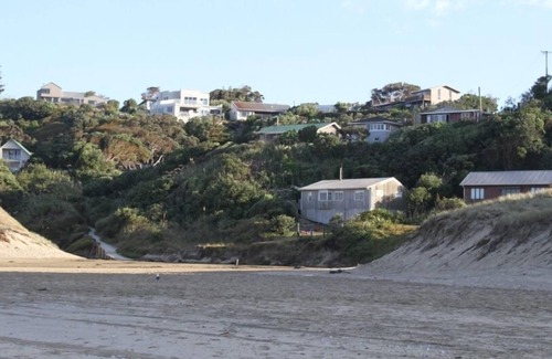 Baylys Beach Cabin | Small Traditional Family Bach within walking distance to beach.