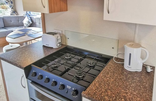 Llanllwchaiarn House | Spacious and well-presented 12ft-wide caravan with one double and two twin bedrooms.