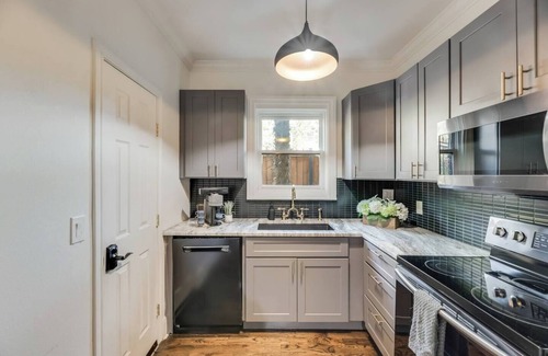 Old East Dallas Condo | Step into refined comfort in this charming Dallas jewel box, where historic architecture meets luxury finishes. Featuring a hand-scraped hardwood foyer, Carrera marble bath, high-end kitchen, and award-winning courtyard.