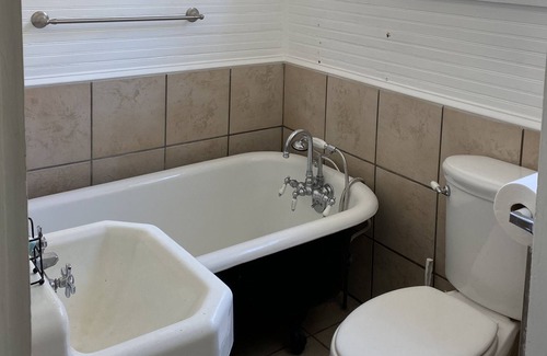 Spanish Town Historic District House | Suite with sitting area and ensuite bath with Clawfoot tub
