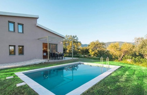 Ano Korakiana Villa | The villa's large private garden leads directly to the outdoor private pool.