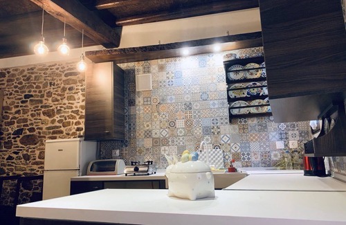 Asklipiio House | Traditional stone built single room house with traditional bed.