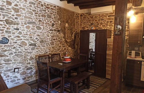 Asklipiio House | Traditional stone built single room house with traditional bed.