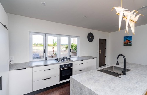 Mangawhai Heads House | Tropical Oasis - Modern, sunny, fully fenced holiday home with beautiful tropical gardens