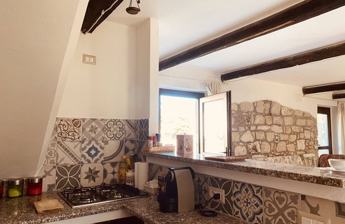 San Giovanni Suergiu Villa | Villa with garden, large windows, exposed beams and stones