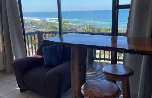 Warner Beach Cottage | Wake up to gorgeous sunrises and sea views upon a wooden balcony.