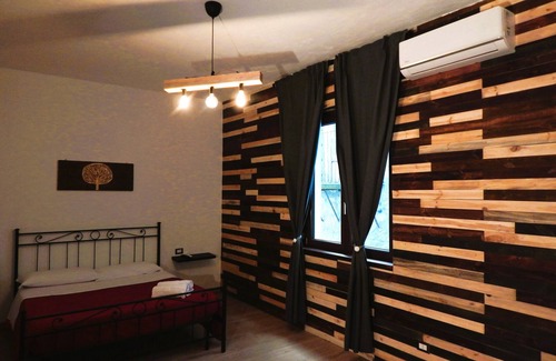 Piazza Armerina Bed & Breakfast | Warm and cozy room with handcrafted recycled wood finishes