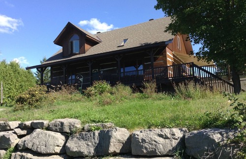 North Algona Wilberforce Cottage | Waterfront log home on Lake Dore. Decks, dock, outdoor hot tub and fire pit.