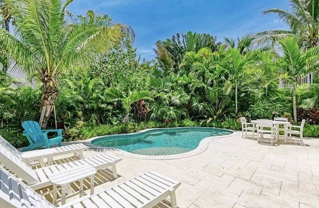 Charming cottage with heated pool, tropical landscaping in prime location.