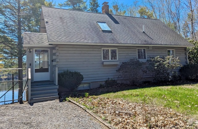 Charming riverfront home with cozy interiors, dock, and scenic deck views