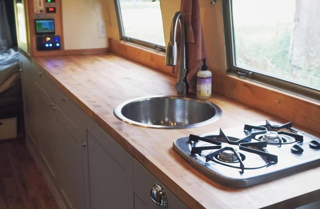 Cozy camper by the creek, surrounded by serenity and nature.