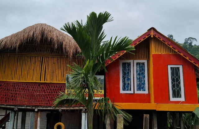 “Elevated wood cabin and bamboo lounge combo in a lush mountain valley.”