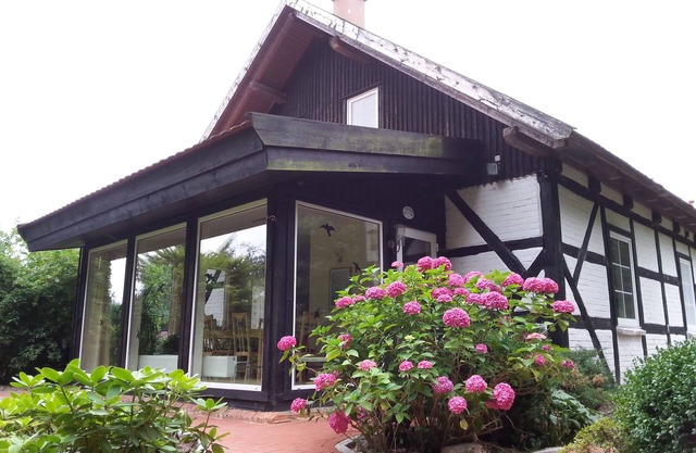 Half of the house with a large garden, pool, campfire and smoker