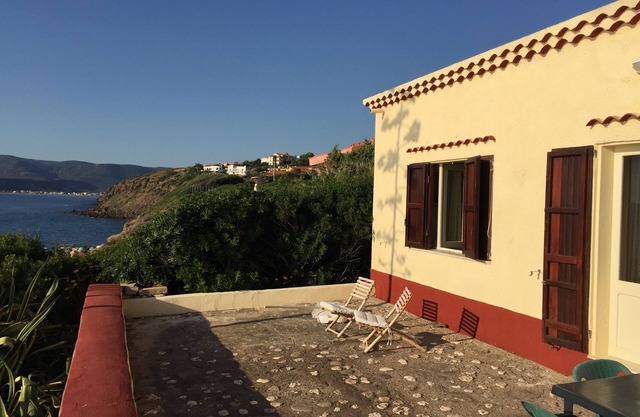 House with garden on the sea, the beach below