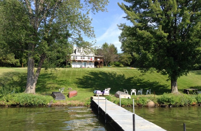 Large Lakefront Reunion And Retreat Home With a large lawn and wrap around porch