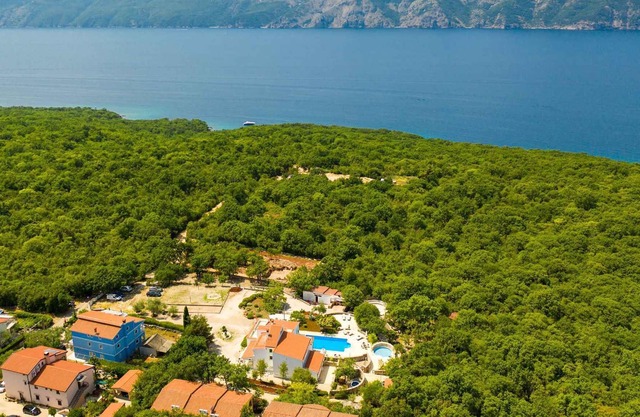 Lotus Resort vacation apartment with swimming pools and garden as well as children's playground and parking lot surrounded by greenery and forest