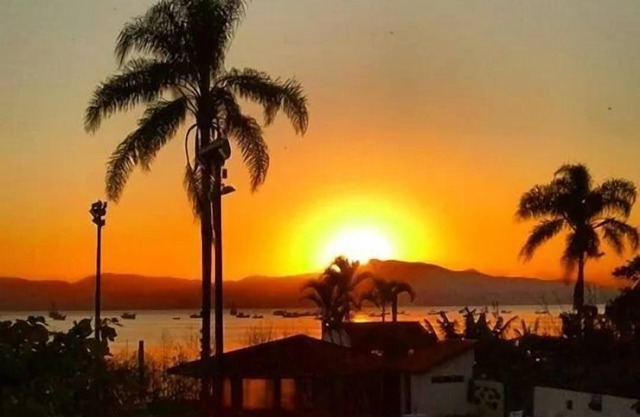 On the sand in a closed condominium with swimming pool, tennis court and parking lot