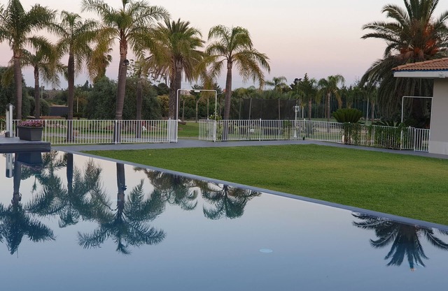 Orange house with large park and swimming pool.
