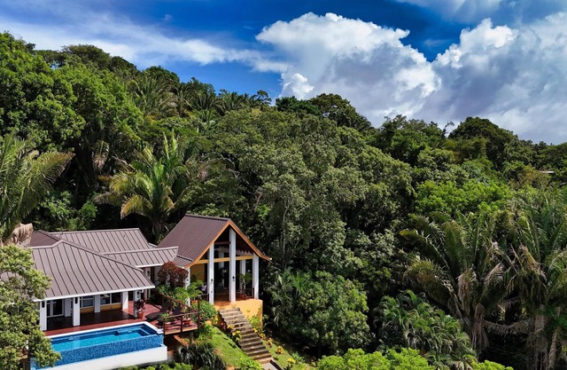 Relax at this hillside retreat that overlooks the lush forest and the Caribbean.