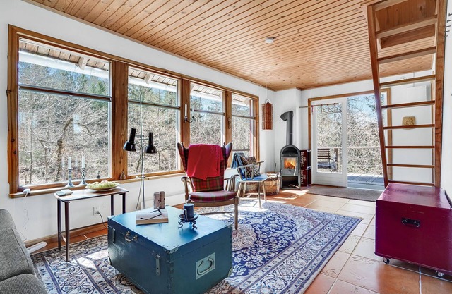 Relaxed living in tranquil wooden cottage near forest and meadows.