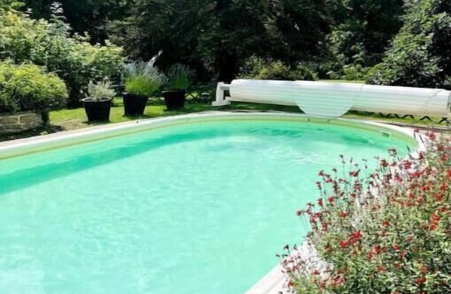 Riverfront pool and sauna house in a flower-filled park