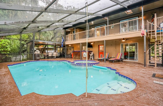 Riverfront retreat with pool/spa, outdoor kitchen, firepit, dock, sauna & games