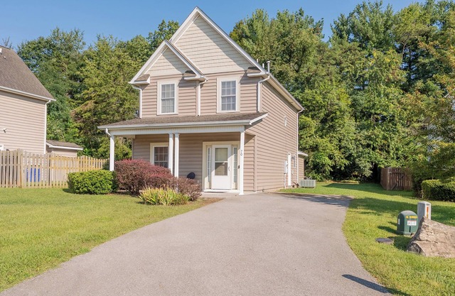 Spacious family home with multiple bedrooms, full kitchen, porch, and quaint backyard.