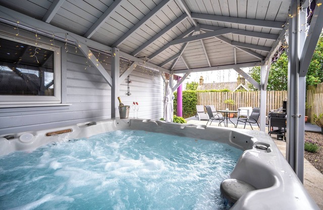 The Retreat Cabin with covered hot tub, sauna & cinema room.