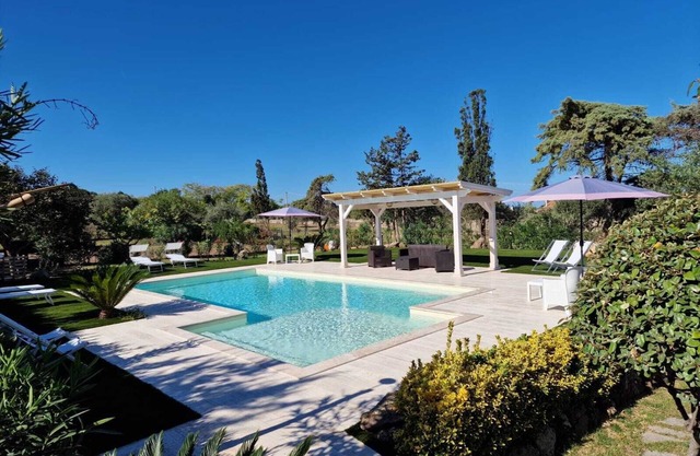 Villa with swimming pool, surrounded by flower gardens, near the sea.