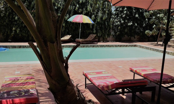 Serrekunda Bed & Breakfast | B & B Villa Calliandra, room with kingbed and ensuite bathroom with large pool.